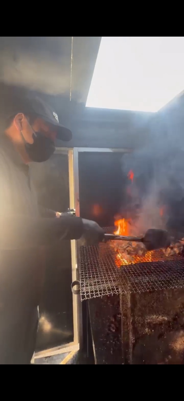 キッチンカーで炭火焼をする様子